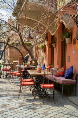 Tiflis 'in eski ve sıcak bir bölgesinde, caddedeki yazlık teras ve restoran masası..