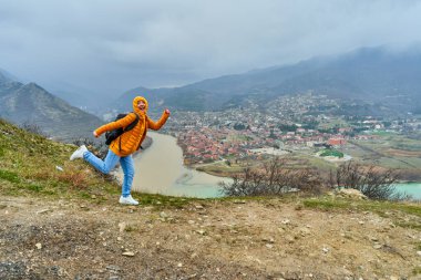 Genç turist kız, inanılmaz doğal bir manzaranın arka planında poz verdiğinde seviniyor. Gürcistan 'ın Mtskheta şehrinde iki nehrin kesişmesi..