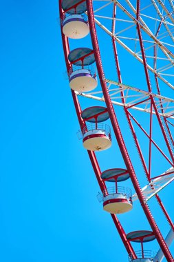 Mavi gökyüzüne karşı kırmızı dönme dolap.