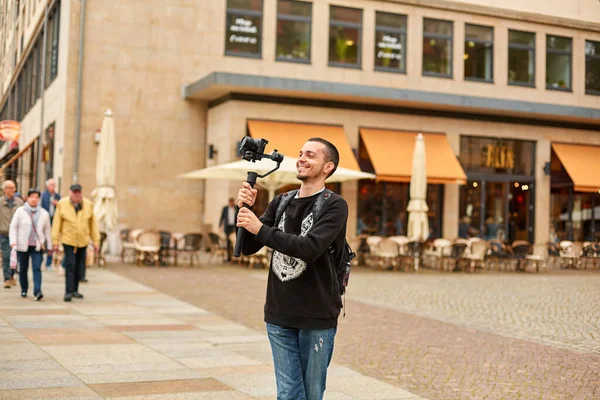 Tourist shoots a video with a gimbal in the street of the city.