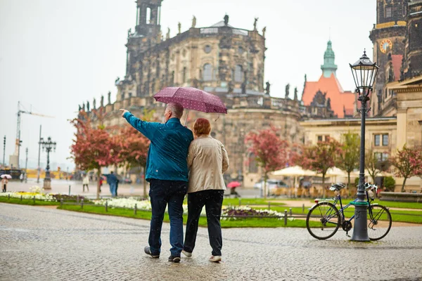 Yağmur yağarken bir çift şemsiye altında şehirde dolaşır. Dresden, Almanya - 05.20.2019