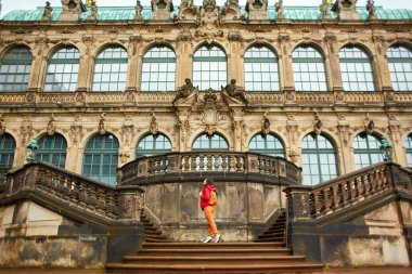 Dresden 'deki Sakson mimarisi. Sakson Sarayı Zwinger. Girişteki merdivenlerde poz veren kız..