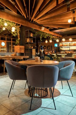 Lokantanın içi sıcak ışık ve yumuşak koltuklarla dolu..