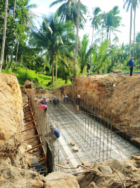 Orman ormanında inşaat. İşçiler temele beton döküyorlar. Samui, Tayland - 02.26.2020