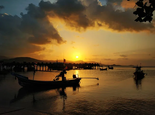 日落时 木船停泊在海滩附近的浅水中 浪漫的风景 — 图库照片