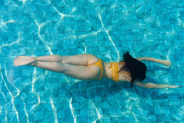 少女はプールの水の下に潜る — ストック写真