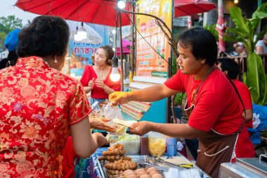 Tayland 'daki Holiday Street gıda pazarı. Tezgahta yemek satıcısı. Samui, Tayland - 02.24.2020