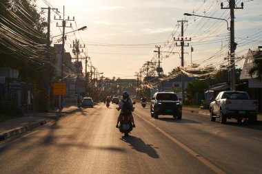 Gün batımında Tayland sokaklarında atmosferik fotoğraf trafiği. Koh Samui, Tayland - 09.15.2022