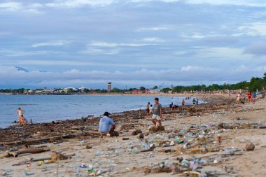 Akıntıdan sonra kumlu sahilde atık ve çöp dağları. İnsanlık okyanusu kirletiyor. Bali, Endonezya - 11.29.2022