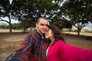 Mutlu genç çift kucaklaşarak selfie çekiyor..