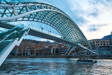 Tourist landmark Peace Bridge over the Mtkvari River in the city of Tbilisi. Tbilisi, Georgia - 03.20.2021
