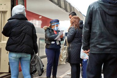 A ticket inspector at a train station checks tickets before passengers board a train. Tbilisi, Georgia - 03.21.2021