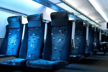 The deserted interior of a high-speed train. Rows of empty seats.