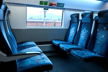 The deserted interior of a high-speed train. Rows of empty seats.