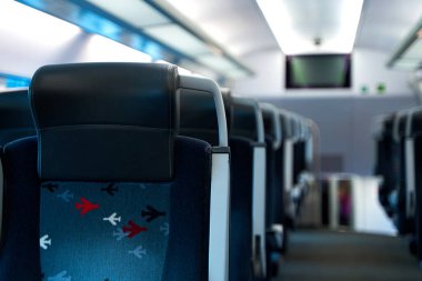 The deserted interior of a high-speed train. Rows of empty seats.