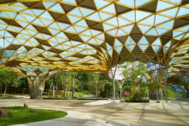 A futuristically designed sunshade with holes for trees in a city recreation park. Kuala Lumpur, Malaysia - 10.31.2022