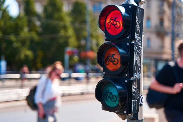 Close-up of a traffic light for cyclists, which is lit in red. A bicycle is shown on the traffic light.