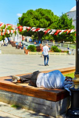 A homeless man sleeps on a bench in Sutan Ahmed Square in Istanbul.