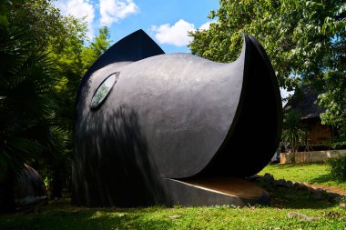 Tayland 'daki Kara Tapınak' ın içinde bulunan siyah balık kafası binası. Binanın eşsiz ve karmaşık tasarımı, kıvrımlı yüzgeçler ve karmaşık detaylar içeriyor. Chiang Rai, Tayland - 02.09.2023