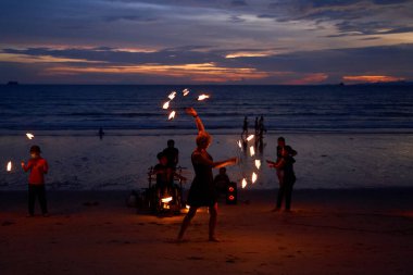 Sokak göstericileri gün batımından sonra plajda turistler için bir yangın gösterisi düzenlediler. Tayland, Krabi - 10.12.2022