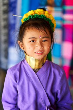Boynuna geleneksel pirinç halkalar takan, uzun boyunlu genç bir kız. Onun çarpıcı özellikleri ve delici bakışları gurur ve kültür mirasını yansıtıyor. Chiang Rai, Tayland - 09.02.2022