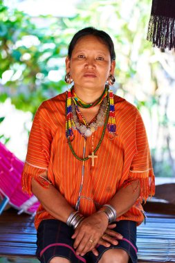 Uzuvlarına ve büyük kulak tünellerine geleneksel pirinç halkalar takan Uzun Boyun kabilesinden bir kadın. Mücevherlerinin karmaşık ayrıntıları kültürel zenginlik ve gelenek hissi yaratıyor. Chiang Rai, Tayland - 09.02.2022