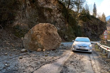 A huge rock fell from the mountains onto the road, destroying the asphalt and blocking half of the roadway. Tbilisi, Georgia - 04.14.2021