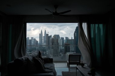 Rüzgar panoramik pencerenin perdesini bir şehir manzarasıyla hışırdatıyor. Kuala Lumpur, Malezya - 06.11.2020