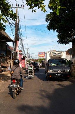 Bir motosikletli Asya 'da manzaralı asfalt bir yolda gidiyor. Bali, Endonezya - 11.30. 2022