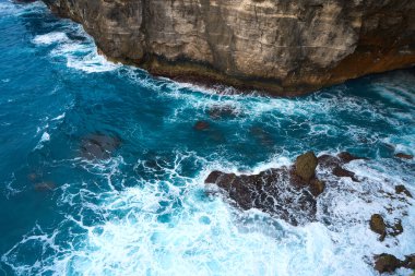 Güzel Nusa Penida adasının sinematik hava manzaralı görüntüleri. Sahil kenarındaki büyük uçurumlar ve berrak su ve köpüren dalgalarla dolu gizli rüya kumsalları.