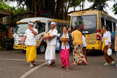 Bali sokaklarında geleneksel rengarenk kıyafetler giyen insanlar. Bali, Endonezya - 12.24.2022