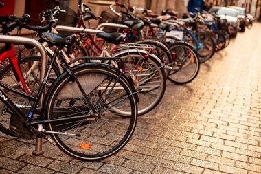 Avrupa sokaklarında park halindeki bisiklet sırasına dizilmiş bir tekerleğin yakın çekimi. Krakow, Polonya - 05.16.2019