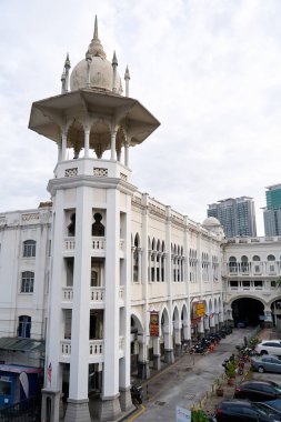 Büyük Asya şehri Kuala Lumpur 'un merkezinde eski bir tren istasyonu kulesi olan beyaz bir bina. Kuala Lumpur, Malezya - 11.15.2022