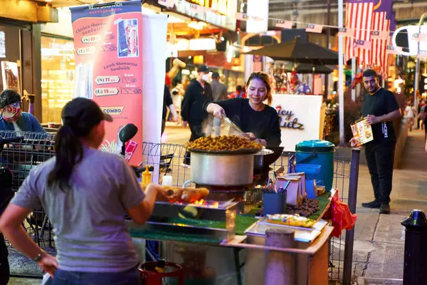 Kuala Lumpur 'un merkezinde yemek tezgahları olan kalabalık bir gece sokağı. Kuala Lumpur, Malezya - 11.15.2022