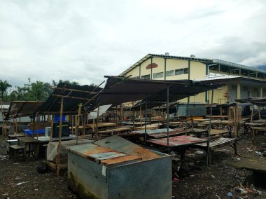 Boş, eski, pis bir Asya sokak pazarı. Terk edilmiş satıcı tezgahları ve bir sürü pislik.