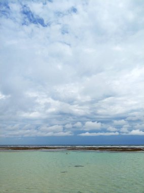 İnanılmaz güzel okyanusun panoramik manzarası. Bali 'nin tropikal adasındaki ıssız bir sahildeki resifin arkasındaki turkuaz suyu temizleyin.