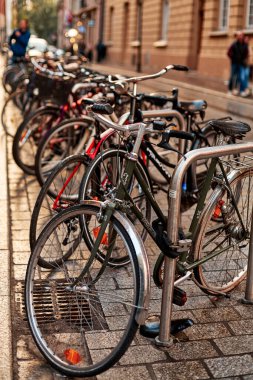 Avrupa sokaklarında park halindeki bisiklet sırasına dizilmiş bir tekerleğin yakın çekimi. Krakow, Polonya - 05.16.2019