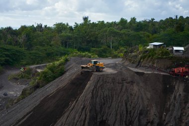 Endonezya 'da taş ocağı. Bölgede buldozerler ve çöp kamyonları gibi büyük ekipmanlar çalışıyor