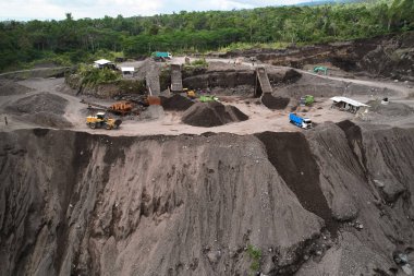 Endonezya 'da taş ocağı. Bölgede buldozerler ve çöp kamyonları gibi büyük ekipmanlar çalışıyor
