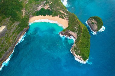 Nusa Penida 'nın güzel adadaki dinozorunun sinematik hava manzarası görüntüleri. Kıyı şeridindeki büyük uçurumlar ve berrak sularla dolu gizli rüya kumsalları