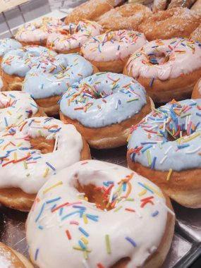 Çikolata kaplı, pembe jöleli ve serpiştirilmiş taze donutlar.