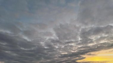 Gün doğumunda gökyüzünde hareket eden bulutların zamanı çarpıcı ve renkli bir sahne yaratıyor.