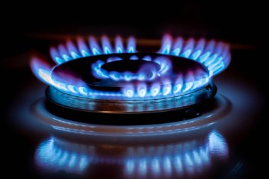 Karanlıkta mavi alevli gaz ocağı.