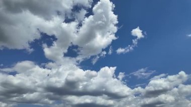 Yumuşak beyaz bulutların zamanı berrak mavi gökyüzünde hareket ediyor