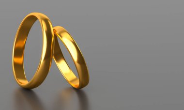 Karanlık arka planda iki altın alyans ve boş alan.