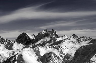 Kış akşamları yüksek karlı, güneşli dağlar. Kafkas Dağları. Elbrus 'tan görüntü. Chatyn Dağı, Ushba, Kogutai. Siyah ve beyaz tonlu manzara.