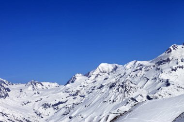 Karlı dağ ve pist dışı yamaçta güneş kış gününde kayak ve snowboard izleri var. Kafkasya Dağları, Gürcistan, Gudauri bölgesi. 