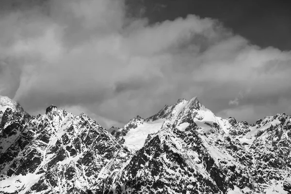 stock image Snowy rock mountains in clouds at sun winter day. Caucasus Mountains. Svaneti region of Georgia. Black and white toned landscape.