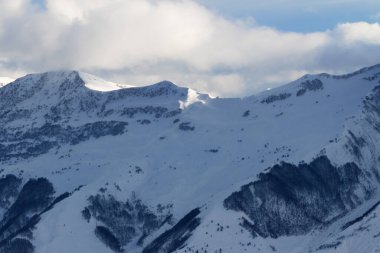 Kış akşamları serbest dolaşmak için karlı yamaçlar ve bulutlarda güneş ışığı dağları. Kafkas Dağları. Gürcistan, bölge Gudauri.