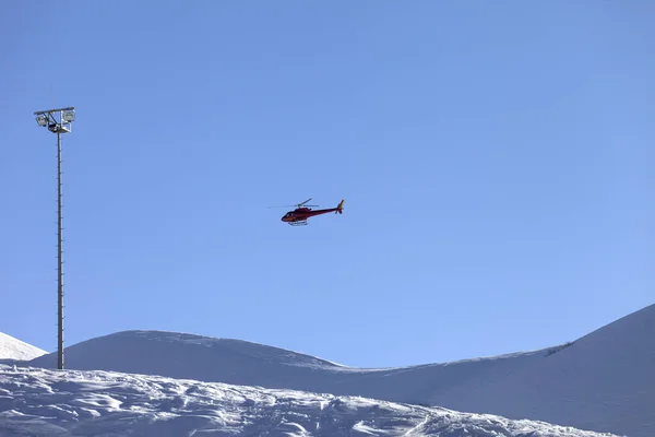 在阳光明媚的冬夜 直升机在蓝色晴朗的天空和雪地的滑雪坡上飞行 格鲁吉亚高加索山脉 Gudauri地区 — 图库照片